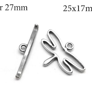 Könnte beinhalten: Zwei silberfarbene Metall-Schmuckverschlüsse. Einer ist ein 27 mm langer Stab mit einer Schlaufe an einem Ende. Der andere ist ein libellenförmiger Verschluss, 25 mm x 17 mm, ebenfalls mit einer Schlaufe. Auf weißem Hintergrund.