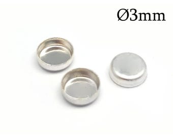 May include: Three small, round, silver-coloured metal cabochon settings with a smooth, raised edge. Two of the settings are positioned with the hollow interior facing upward, while one is flipped over. The text Ø3mm is visible in the corner.