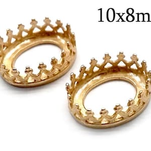 Puede incluir: Dos engastes de metal dorado en forma de corona para cabujones ovalados de 10x8mm.