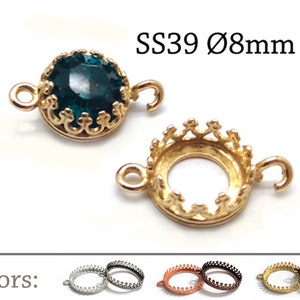 May include: Gold-tone metal connector with a round, clear green stone in a crown-shaped setting. The connector has two loops for attaching to jewelry. SS39 Ø8mm.
