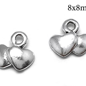May include: Silver charm with two interlocking hearts, measuring 8mm by 8mm.