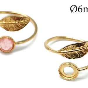Könnte beinhalten: Zwei verstellbare goldene Ringe mit einem Blattdesign. Ein Ring hat einen rosa Stein in der Mitte. Die Ringe haben einen Durchmesser von 6 mm.