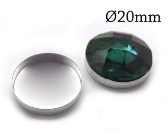 Puede incluir: Una piedra preciosa circular facetada de color verde oscuro con un engaste metálico, acompañada de un engaste circular vacío. El texto Ø20mm es visible, indicando un diámetro de 20 milímetros para estos componentes de joyería.