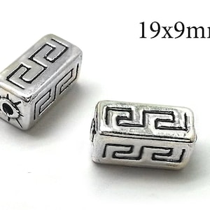 May include: Two silver-toned rectangular beads with a geometric design. The beads measure 19x9mm.