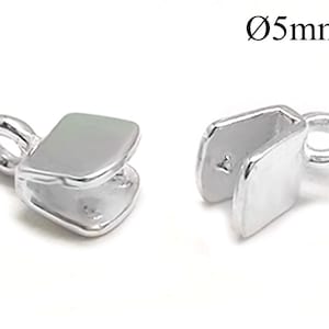 Puede incluir: Dos tapones de extremo de metal plateados para la elaboración de joyas. Cada tapón tiene un pequeño bucle en un extremo y una forma rectangular plana en el otro. Los tapones tienen un diámetro de 5 mm.