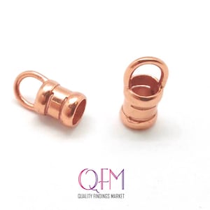 May include: Two rose gold metal end caps for jewelry making. Each cap has a small loop on top and a cylindrical body.