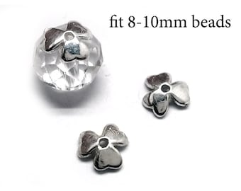 May include: Two silver-colored metal clover-shaped bead caps and one clear faceted bead with a cap attached. The text "fit 8-10mm beads" is visible, indicating the size compatibility for these jewelry components.