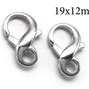 Puede incluir: Dos cierres de langosta plateados, cada uno mide 19x12mm. Los cierres están diseñados con una forma lisa y redondeada y un mecanismo de cierre seguro.