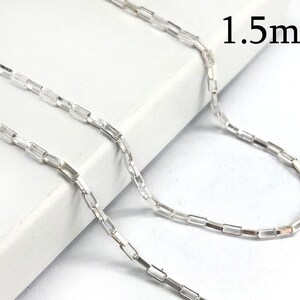 Puede incluir: Un collar plateado con eslabones rectangulares. El texto "1.5mm" es visible. La cadena se muestra sobre una superficie blanca, resaltando su diseño y calidad reflectante. La cadena mide 1,5 milímetros de ancho.