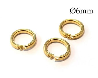 Könnte beinhalten: Drei goldfarbene, kreisförmige Biegeringe mit einem aufklappbaren Verschlussmechanismus. Jeder Ring verfügt über ein kleines Stift- und Loch-Verschlusssystem. Der Text Ø6mm ist sichtbar und gibt einen Durchmesser von 6mm für diese Metallteile an.