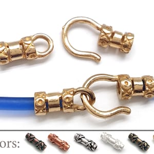 Peut inclure: Embout de cordon en métal doré avec un fermoir à crochet. L'embout de cordon présente un motif décoratif. L'image montre l'embout de cordon en différentes couleurs : laiton antique, cuivre, argent et or.