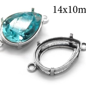 May include: A silver-toned pendant setting with a teardrop-shaped opening, measuring 14mm by 10mm. The setting has two loops for attaching a chain or cord. The setting is shown with a light blue teardrop-shaped glass stone.