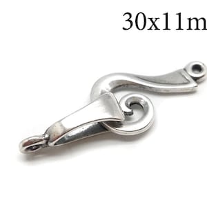 May include: Silver-toned metal clasp with a decorative swirl design. The clasp measures 30x11 mm.