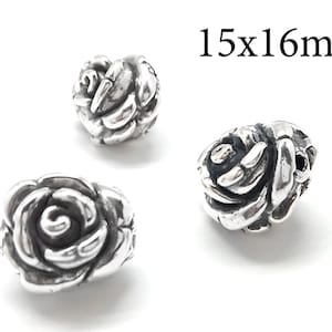 May include: Three silver rose-shaped beads, each with a detailed design. The beads measure 15x16mm.