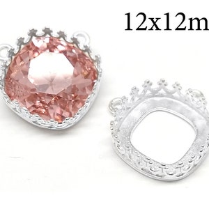 May include: Silver crown-shaped setting for a 12mm by 12mm square stone. The setting has a loop for hanging. The setting is shown with a pink stone.