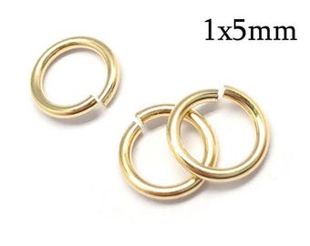 Könnte beinhalten: Drei goldfarbene Metall-Biegeringe mit kreisförmiger Form und einer kleinen Öffnung. Die Ringe haben eine glatte, polierte Oberfläche und sind in einer Gruppe angeordnet. Der Text 1x5mm ist in Schwarz in der oberen rechten Ecke abgebildet.