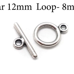 Könnte beinhalten: Silberner Toggle-Verschluss mit einer 12 mm Stange und einer 8 mm Schlaufe.