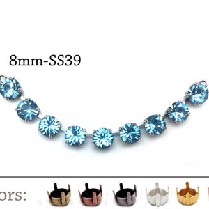 Puede incluir: Una cadena de 8 mm de piedras de cristal azul claro con engastes plateados. La cadena es curva y tiene un total de 9 piedras de cristal. El texto "8mm-SS39" es visible sobre la cadena. Debajo de la cadena, la palabra "Colores:" es visible, seguida de 6 engastes de diferentes colores para las piedras de cristal.