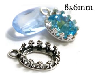 May include: An oval silver-toned metal crown setting charm measuring 8x6mm, featuring a scalloped edge. A second identical charm is shown set with a faceted light blue stone, positioned behind the empty metal setting.