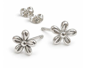 May include: A pair of silver-toned flower stud earrings with five rounded petals and a central circular detail. The earrings feature straight posts and include two matching silver-toned butterfly earring backs for secure fastening.