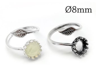 Könnte beinhalten: Zwei silberfarbene, verstellbare Ringe mit einem Blattmotiv an einem Ende und einer kronenförmigen Fassung am anderen. Ein Ring enthält einen runden, blassgrünen Stein, der andere ist eine leere Fassung. Der Text Ø8mm ist oben rechts sichtbar.