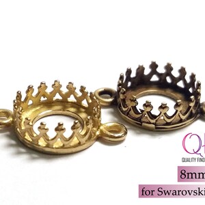 K&ouml;nnte beinhalten: Zwei runde Metallfassungen mit kronenf&ouml;rmigen Krappen und seitlichen &Ouml;sen. Eine ist hellgold, die andere antikbronze. Der Text lautet QFM QUALITY FINDINGS MARKET, 8mm, for Swarovski SS39.