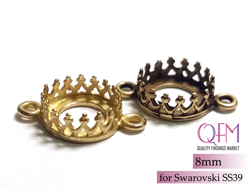 K&ouml;nnte beinhalten: Zwei runde Metallfassungen mit kronenf&ouml;rmigen Krappen und seitlichen &Ouml;sen. Eine ist hellgold, die andere antikbronze. Der Text lautet QFM QUALITY FINDINGS MARKET, 8mm, for Swarovski SS39.