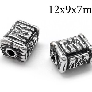 May include: Two silver metal beads with a textured surface. The beads are rectangular in shape and measure 12x9x7 mm.