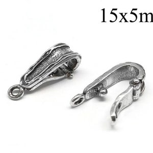 Könnte beinhalten: Zwei silberfarbene Schmuckverschlüsse, jeweils mit einem strukturierten, organischen Design. Ein Verschluss ist geöffnet und zeigt den Scharniermechanismus. Der Text "15x5mm" ist sichtbar. Diese Verschlüsse werden wahrscheinlich für Halsketten oder Armbänder verwendet.