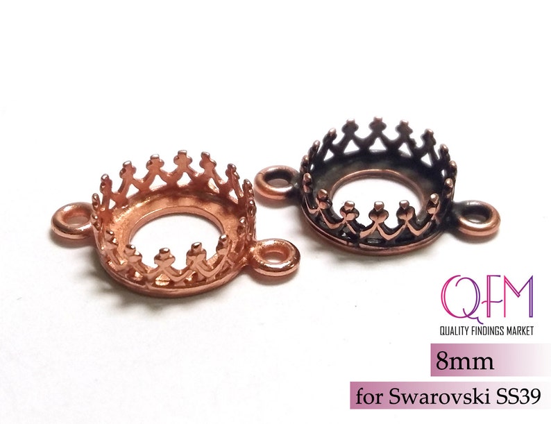 K&ouml;nnte beinhalten: Zwei kronenf&ouml;rmige Schmuckfassungen aus kupferfarbenem Metall mit seitlichen &Ouml;sen zur Befestigung. Eine Fassung ist hell kupferfarben, die andere dunkel oxidiert. Der Text lautet QFM QUALITY FINDINGS MARKET 8mm for Swarovski SS39.