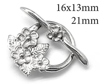 May include: A silver-toned toggle clasp featuring a circular ring adorned with three embossed flowers and leaves, paired with a T-bar component topped with a small flower. The dimensions 16x13mm and 21mm are printed in black text on the image.