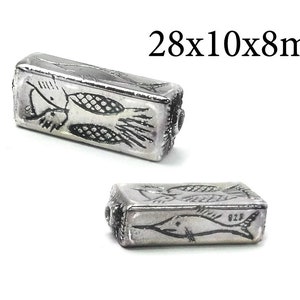Peut inclure: Deux perles rectangulaires en argent avec des motifs de poissons. Les perles mesurent 28x10x8mm. Une perle montre deux poissons se faisant face, l'autre perle montre trois poissons nageant dans la même direction. La perle avec trois poissons porte le numéro 925.