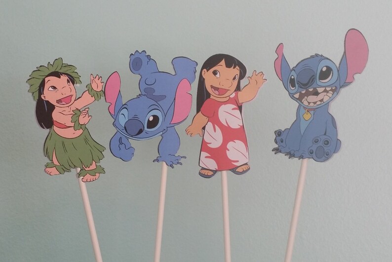 May include: Four cartoon character cutouts on sticks. The characters include Lilo in a red dress, Stitch in various poses, and a girl in a grass skirt. The characters are blue, red, green, and tan.