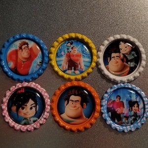 May include: Six round, colorful, plastic bottle caps with images of characters from the movie Wreck-It Ralph. The characters include Ralph, Vanellope, and Fix-It Felix Jr.