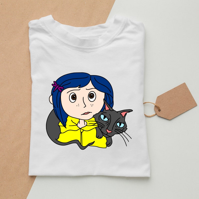 May include: A white t-shirt with a cartoon illustration of a girl with blue hair and a black cat. The girl is wearing a yellow raincoat and has a purple flower in her hair. The cat is looking at the viewer.