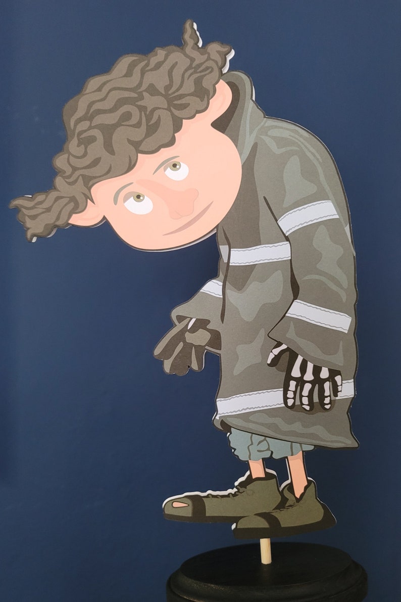 May include: A cartoon character with brown curly hair, wearing a gray and white striped jacket, stands on a wooden base. The character has a large head and small body, with a mischievous expression.