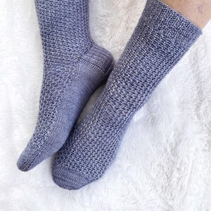 May include: A pair of gray knitted socks with a textured pattern. The socks are made of a soft, breathable material and are perfect for everyday wear.