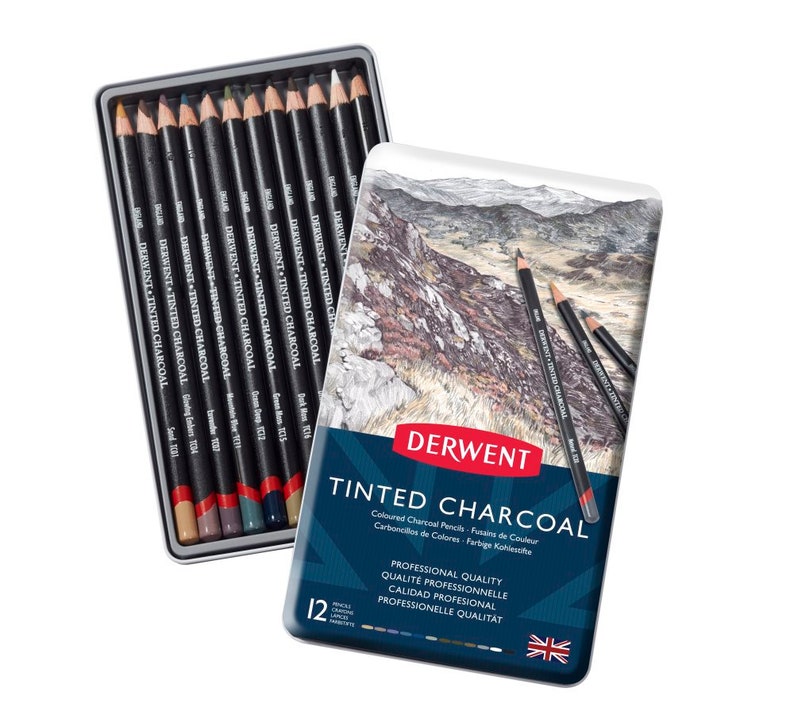 May include: A tin of Derwent Tinted Charcoal pencils. The tin is blue and features a landscape scene with mountains and rocks. The text on the tin reads "Derwent Tinted Charcoal" and "Professional Quality". The tin contains 12 pencils.