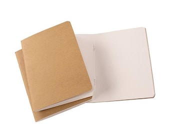 May include: Two brown notebooks with blank white pages. The notebooks are closed and stacked on top of each other. The top notebook is open to reveal the blank white pages.