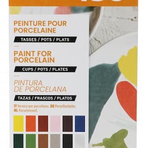 Peut inclure: Une boîte de peinture Pébéo Porcelaine 150 pour tasses, pots et assiettes. La boîte est orange et blanche, avec du texte en anglais, français et espagnol. Elle contient 12 couleurs de peinture en tubes de 20 ml.