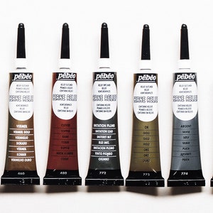 May include: Eight tubes of Pebeo Cerne Relief outlining paste in various metallic colours, including gold, copper, silver, and black. The tubes are labelled with the colour name in multiple languages.