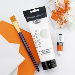 May include: A white tube of Royal & Langnickel essentials Matte Medium acrylic paint with a black cap. The tube is labeled "essentials Matte Medium" and "Mix with any acrylic paint to give colors a non-reflective finish!"  A small tube of acrylic paint is also visible in the image.