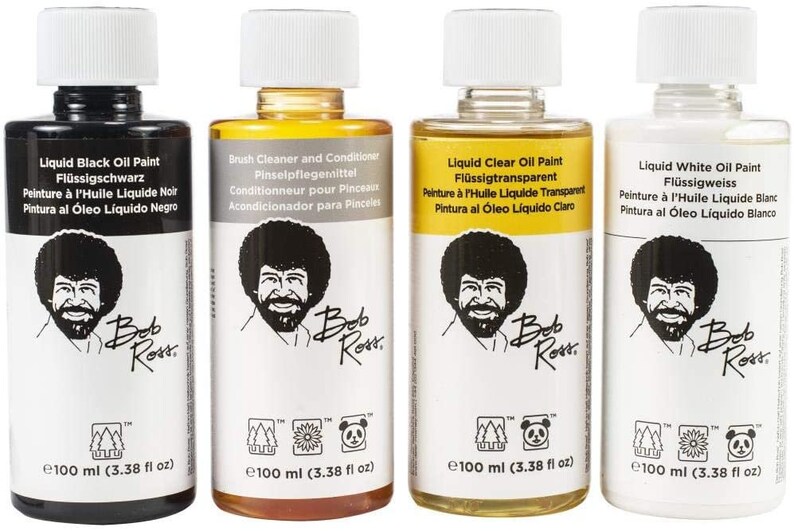 May include: Four 100 ml bottles of Bob Ross Liquid Oil Paint. The bottles are labeled with the paint color: Liquid Black Oil Paint, Brush Cleaner and Conditioner, Liquid Clear Oil Paint, and Liquid White Oil Paint. Each bottle features a portrait of Bob Ross.