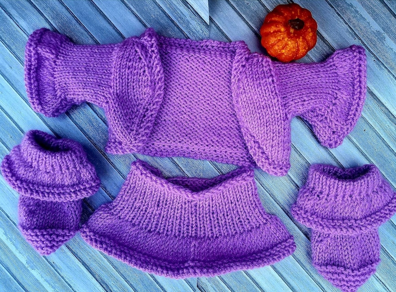 May include: A purple knitted baby outfit set including a cardigan, a skirt, and two pairs of booties.