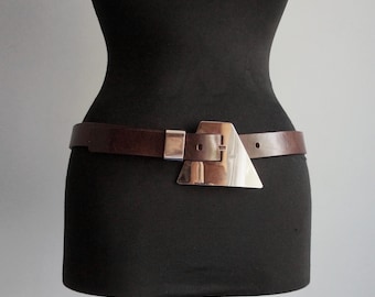 Cinturón estrecho de cuero grueso marrón oscuro, hebilla trapezoidal grande cromada y ojal, tamaño mediano, accesorios de moda vintage