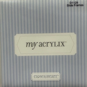 May include: A white package with blue stripes and the text "my acrylix" and "close to my heart" on it. The package is for slide frames.