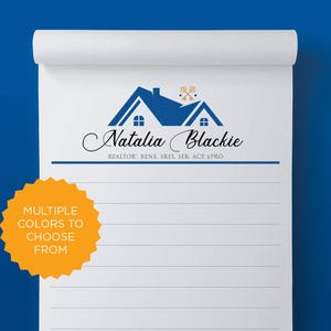 May include: A white notepad with a blue and white house logo and the text "Natalia Blackie" and "REALTOR: RENE SRES. SFR. ACP. EPRO". The notepad has a yellow sticker with the text "MULTIPLE COLORS TO CHOOSE FROM".