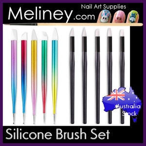 May include: Set of 8 silicone nail art brushes with colourful handles. The brushes have black handles and white silicone tips. The brushes are arranged in a row on a white background. Meliney.com is printed at the top of the image. The text "Silicone Brush Set" is printed at the bottom of the image.