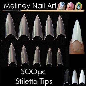 Puede incluir: Puntas de u&ntilde;as stiletto transparentes dispuestas sobre un fondo negro. La imagen incluye el texto "Meliney Nail Art" y "500pc Stiletto Tips". Se muestra una u&ntilde;a pintada con una punta blanca en un dedo.