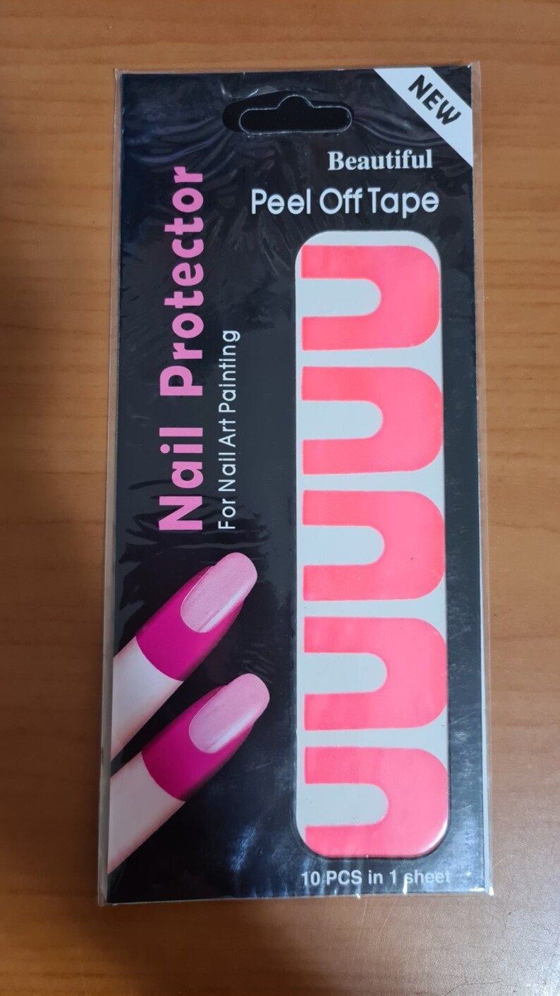 May include: Pink peel-off nail tape for nail art. The packaging shows 10 pieces of tape on a sheet. The text on the packaging reads "New, Beautiful Peel Off Tape, Nail Protector, For Nail Art Painting, 10 PCS in 1 sheet".